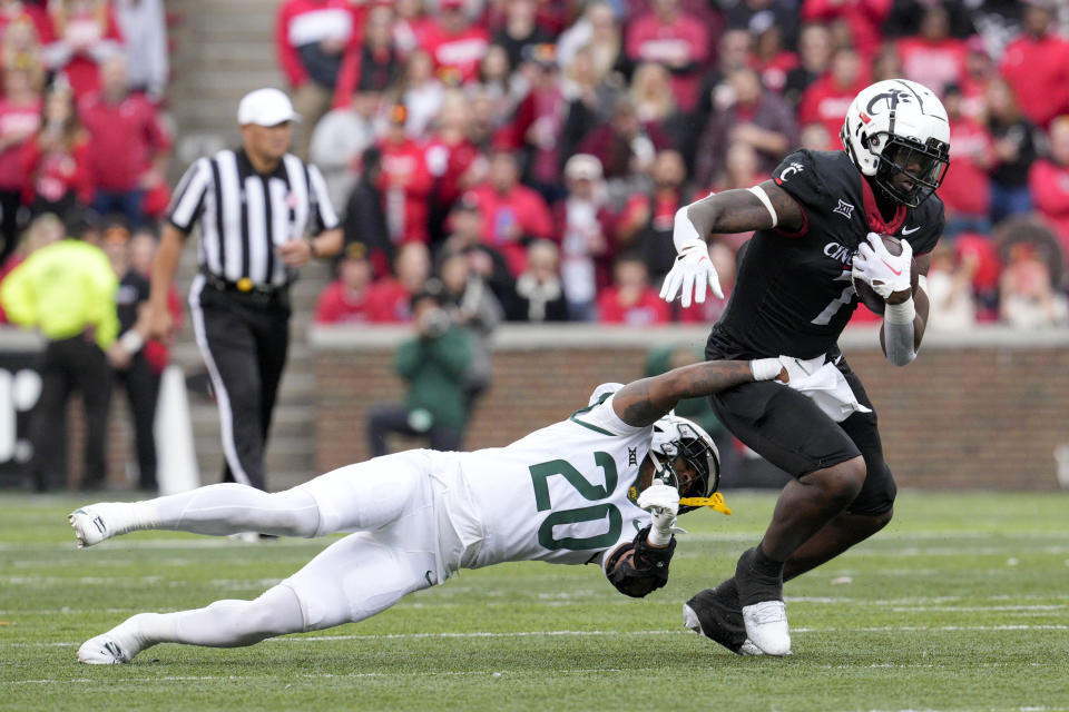 Cincinnati tight end Chamon Metayer (7) breaks a tackle by Baylor safety Devin Lemear (20) during the second half of an NCAA college football game, Saturday, Oct. 21, 2023, in Cincinnati. (AP Photo/Jeff Dean)