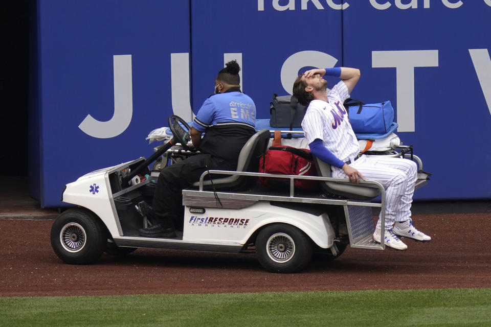 New York Mets left fielder Jeff McNeil reacts as he rides a cart off the field after being injured during the first inning of a baseball game against the Washington Nationals at Citi Field, Thursday, Aug. 13, 2020, in New York. (AP Photo/Seth Wenig)