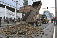 Protesting farmers dump a load of potatoes onto a main boulevard during a demonstration outside the European Council building in Brussels, Tuesday, March 26, 2024. Dozens of tractors sealed off streets close to European Union headquarters where the 27 EU farm ministers are meeting to discuss the crisis in the sector which has led to months of demonstrations across the bloc. (AP Photo/Harry Nakos)