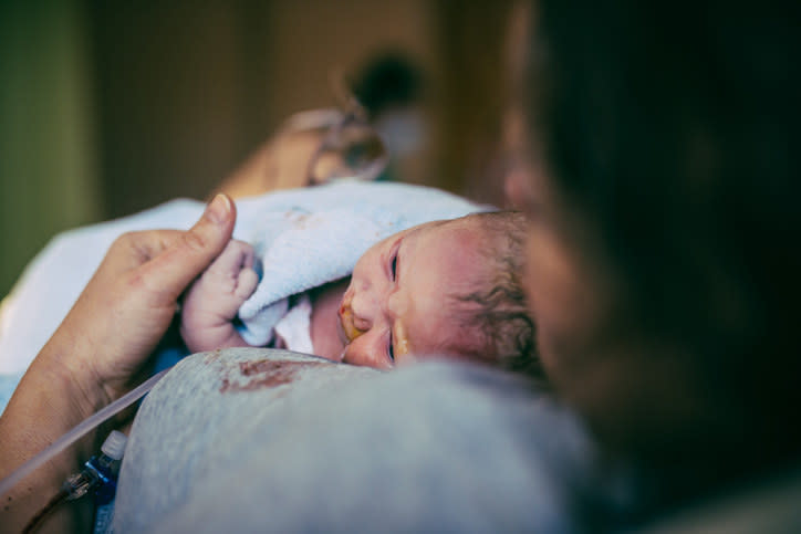 A woman holding her newborn after birth in hospital.