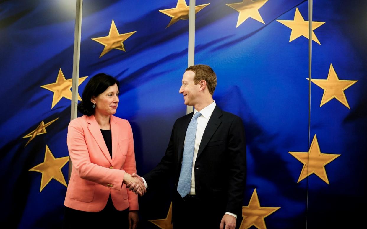 European Commission vice-president in charge for Values and Transparency Vera Jourova (L) shakes hands with the founder and CEO of US online social media and social networking service Facebook Mark Zuckerberg (R), in Brussels, on February 17, 2020 - Kenzo Tribouillard/AFP/Getty