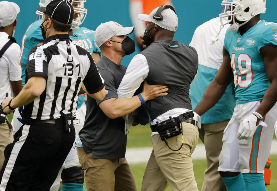 Head coach Brian Flores of the Miami Dolphins is held back by a member of his coaching staff as Flores walks on the field in the fourth quarter of the game against the Cincinnati Bengals at Hard Rock Stadium on December 06, 2020 in Miami Gardens, Florida. (Photo by Michael Reaves/Getty Images)