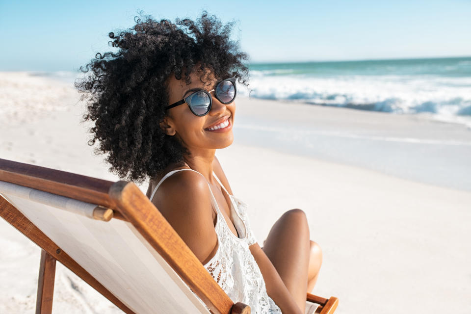 woman smiling on a lounge chair at the beach