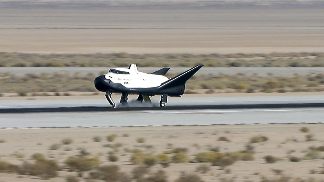  A space plane lands on a runway. 