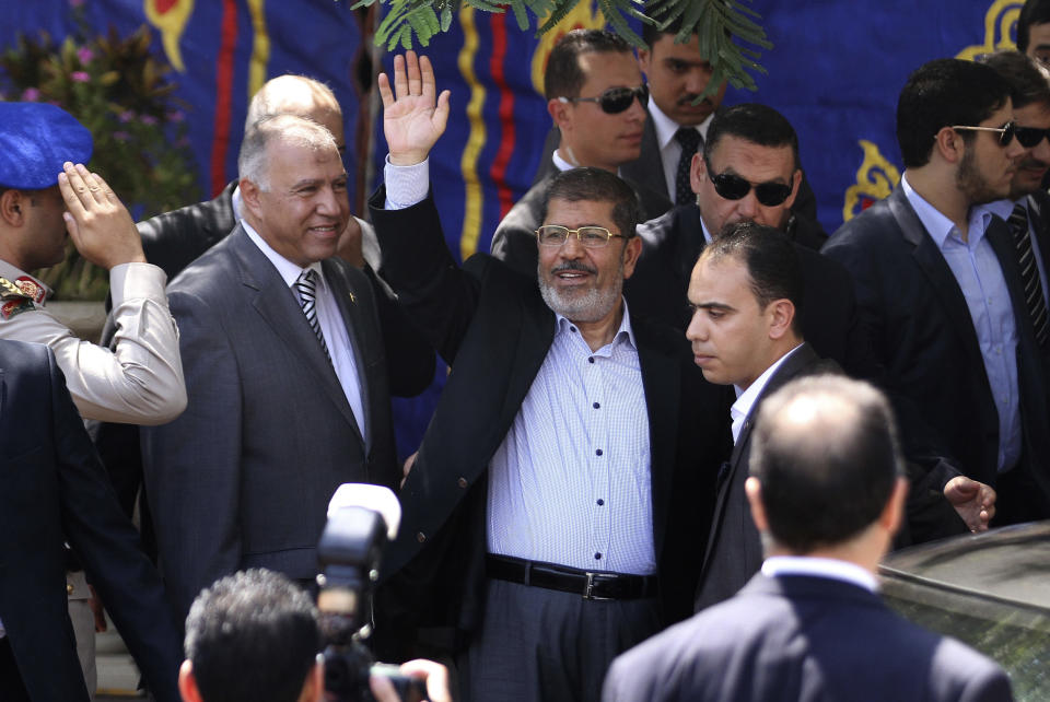 Egyptian President Mohammed Morsi, center, waves to worshippers ash he arrives for Friday prayers at Sayyeda Zainab mosque in Cairo, Egypt, Friday, Sept. 7, 2012. (AP Photo/Ahmed Ali)