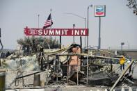 People look at the remains of the Summitt Inn after the Bluecut Fire burnt the historic diner to the ground, in Hesperia, California