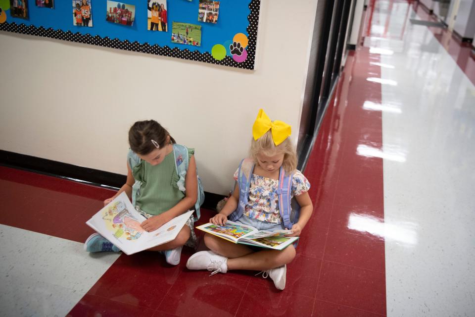 Linden Elementary School students Lily and Harper pass part of the morning reading while waiting for the start class on their first day back from break on July 24. One of the tenets of the Tennessee Literacy Success Act is that teachers in elementary grades are to use the science of reading to teach children how to read.