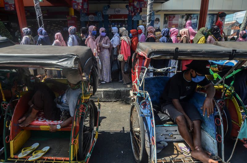 Customers stand in line behind rickshaws to shop at a department store, amid the coronavirus disease (COVID-19) outbreak in Ciamis