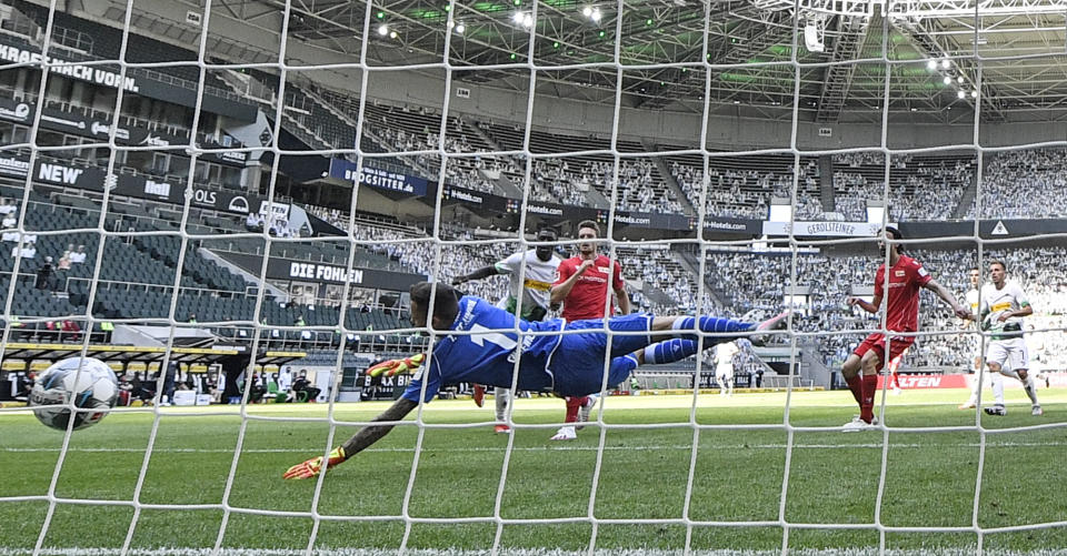 Moenchengladbach's Marcus Thuram, second left, scores his side's second goal against Berlin keeper Rafal Gikiewicz during the German Bundesliga soccer match between Borussia Moenchengladbach and Union Berlin in Moenchengladbach, Germany, Sunday, May 31, 2020. The German Bundesliga becomes the world's first major soccer league to resume after a two-month suspension because of the coronavirus pandemic. (AP Photo/Martin Meissner, Pool)
