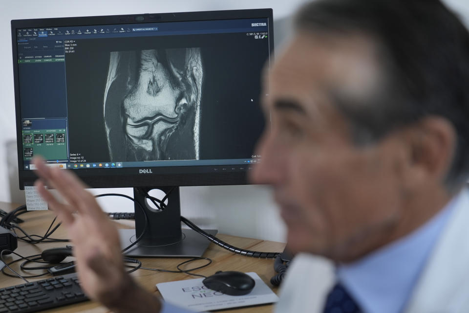 Dr. David Altchek talks about some aspects of Tommy John surgery while showing an x-ray of a patient at his office in New York, Thursday, Feb. 29, 2024. (AP Photo/Seth Wenig)