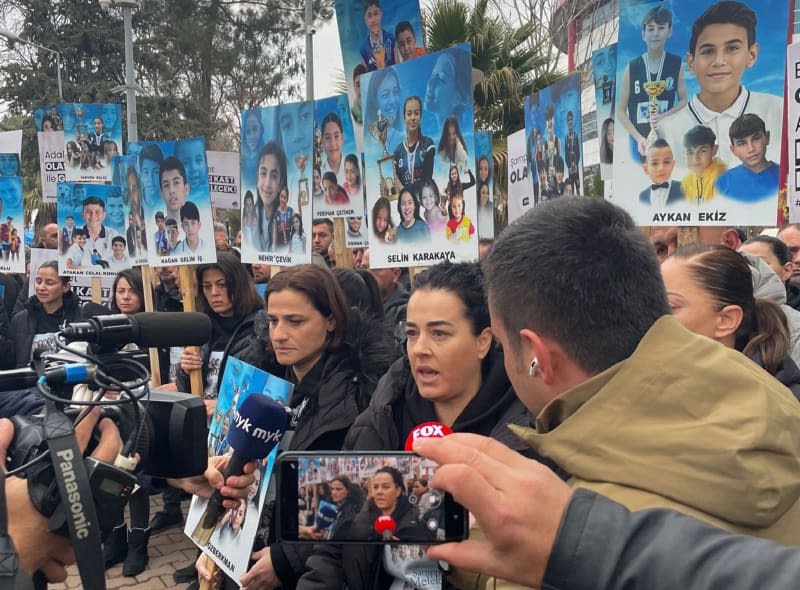 Relatives stand in front of the courthouse in Adiyaman, south-east Turkey, holding up pictures of their children who were killed in last February's earthquake. The first major trial in connection with last February's devastating earthquakes begins in south-eastern Turkey on Wednesday. Mirjam Schmitt/dpa