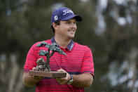 Patrick Reed stands on the South Course while holding his trophy for winning the Farmers Insurance Open golf tournament at Torrey Pines, Sunday, Jan. 31, 2021, in San Diego. (AP Photo/Gregory Bull)