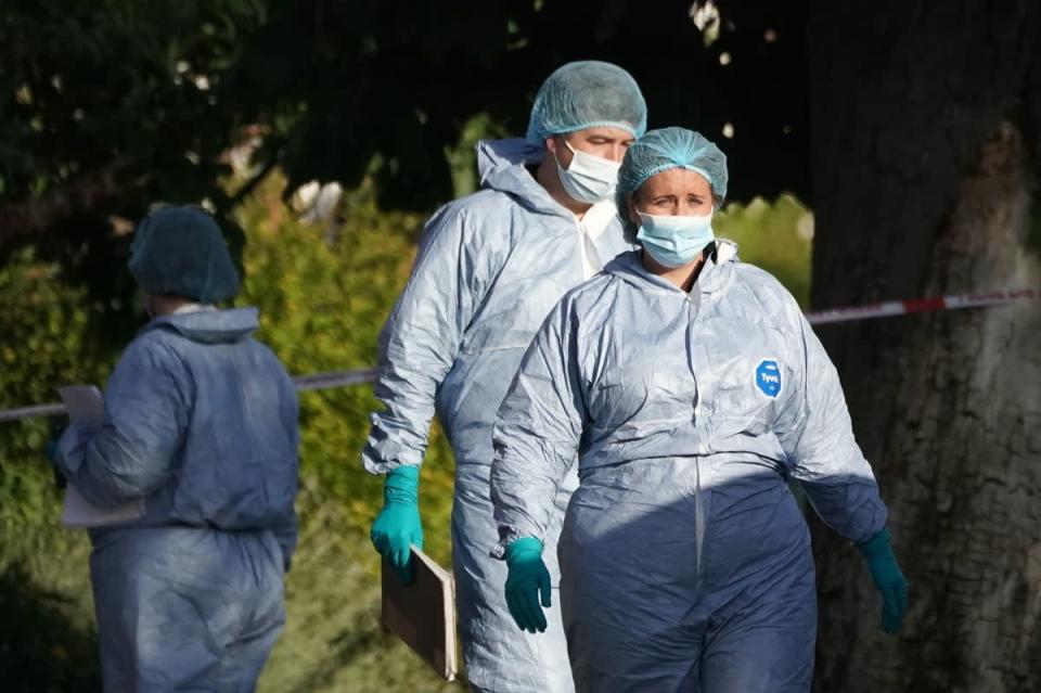 Forensic officers at the scene (PA)