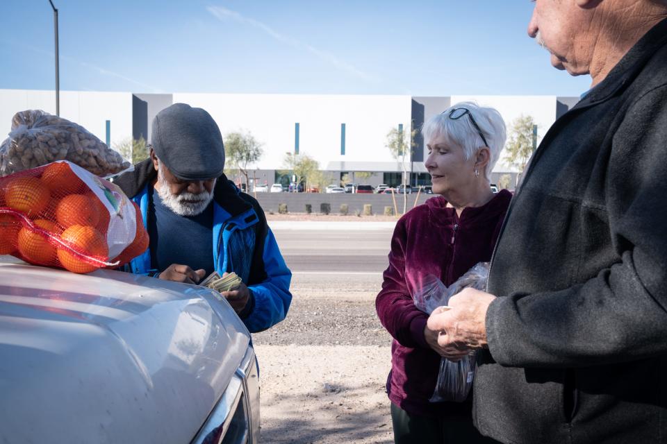 Antonio Recoba (from left) makes change for customers Cheryl and Garry Hubzick on Jan. 18, 2024, in Buckeye. Recoba says he's motivated to continue selling honey every day because, while he loves to talk to his customers, it's also a distraction from his cancer diagnosis.