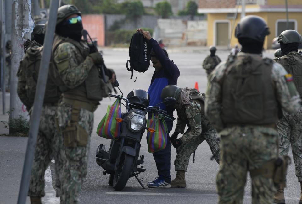 Soldados registran a un hombre en un control de seguridad antes de la segunda vuelta de las elecciones presidenciales en Durán, Ecuador, el viernes 13 de octubre de 2023. (AP Foto/Martín Mejía)