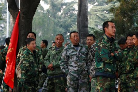 Uniformed people take part in a protest outside the Bayi Building, a major Chinese military building in Beijing, China, October 11, 2016. REUTERS/Thomas Peter