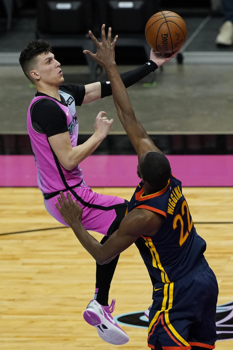 Miami Heat guard Tyler Herro (14) drives to the basket over Golden State Warriors forward Andrew Wiggins (22) during the second half of an NBA basketball game, Thursday, April 1, 2021, in Miami. (AP Photo/Marta Lavandier)