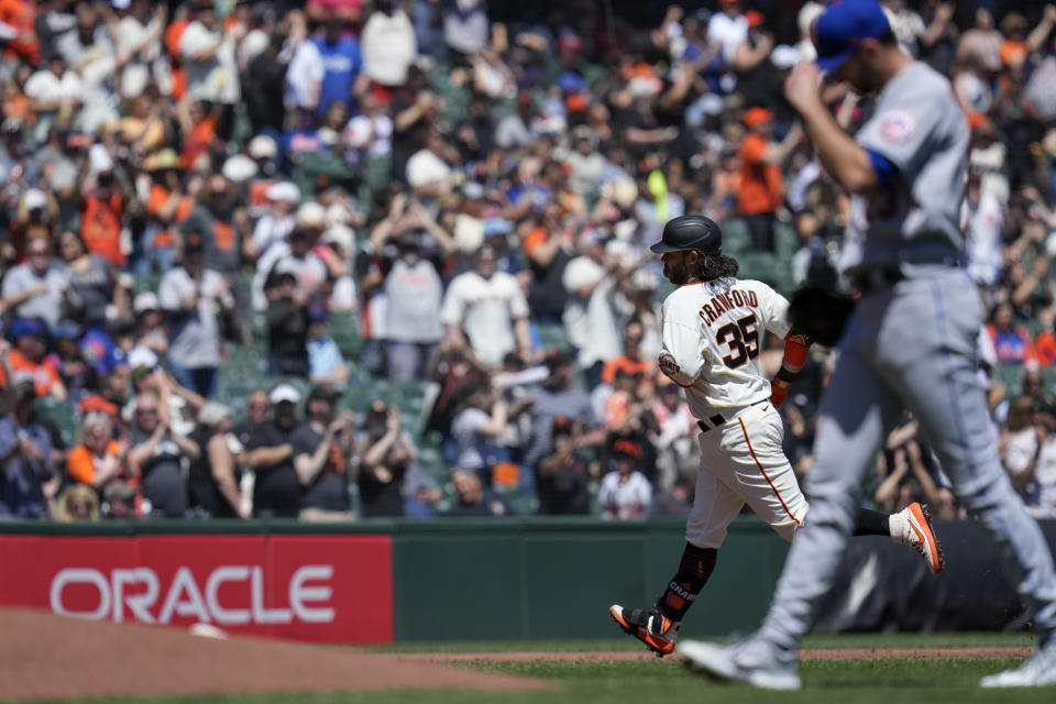 San Francisco Giants' Brandon Crawford (35) runs the bases after hitting a three-run home run against New York Mets pitcher David Peterson, foreground, during the first inning a baseball game in San Francisco, Saturday, April 22, 2023. (AP Photo/Godofredo A. Vásquez)