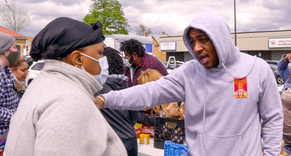 Candles in the S.U.N. founder Dakarai Singletary speaks with a resident in Buffalo, N.Y. (Courtesy Akil Kirkland)