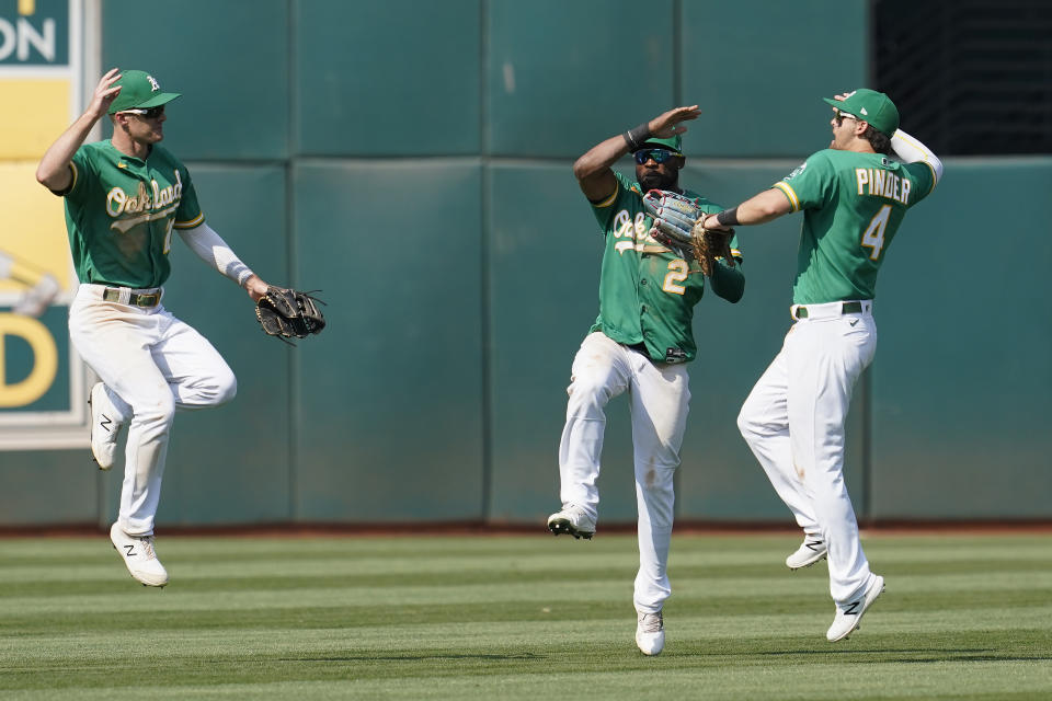 From left to right, Oakland Athletics' Mark Canha, celebrates with Starling Marte and Chad Pinder after they defeated the New York Yankees in a baseball game in Oakland, Calif., Saturday, Aug. 28, 2021. (AP Photo/Jeff Chiu)