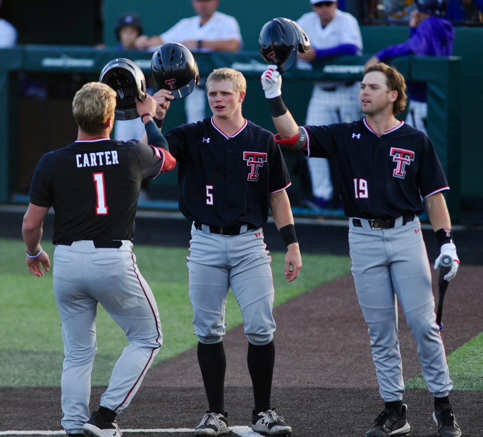 Texas Tech's Hudson White (middle) and Easton Murrell (right) congratulate Dillon Carter after hitting a home run against ACU.