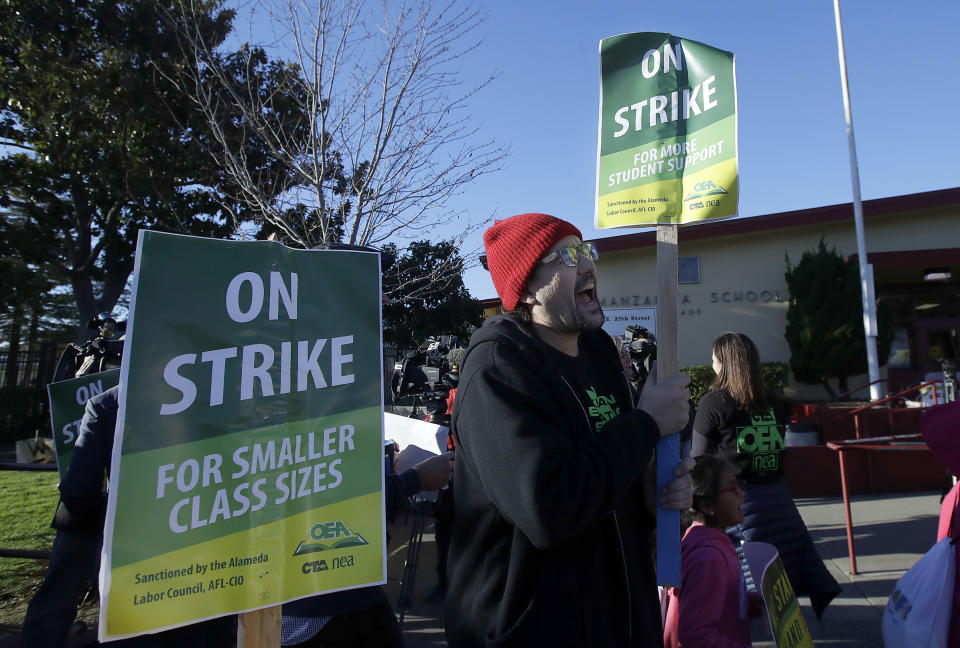 Garrick Ruiz, union member with United Teachers of Los Angeles, center, yells while teachers and supporters march outside of Manzanita Community School in Oakland, Calif., Thursday, Feb. 21, 2019. Teachers in Oakland went on strike Thursday in the country's latest walkout by educators over classroom conditions and pay. (AP Photo/Jeff Chiu)