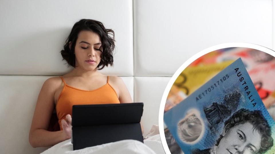 Woman on ipad in bed with money