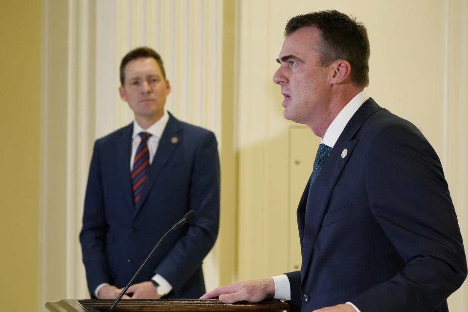 Oklahoma Gov. Kevin Stitt speaks at a news conference Friday, April 29, 2022, in Oklahoma City. Stitt said he has accepted the resignation of Oklahoma's Tourism and Recreation Department Executive Director Jerry Winchester and that the state has filed a lawsuit against the operator of six state park restaurants. Looking on at left is Lt. Gov. Matt Pinnell. (AP Photo/Sue Ogrocki)