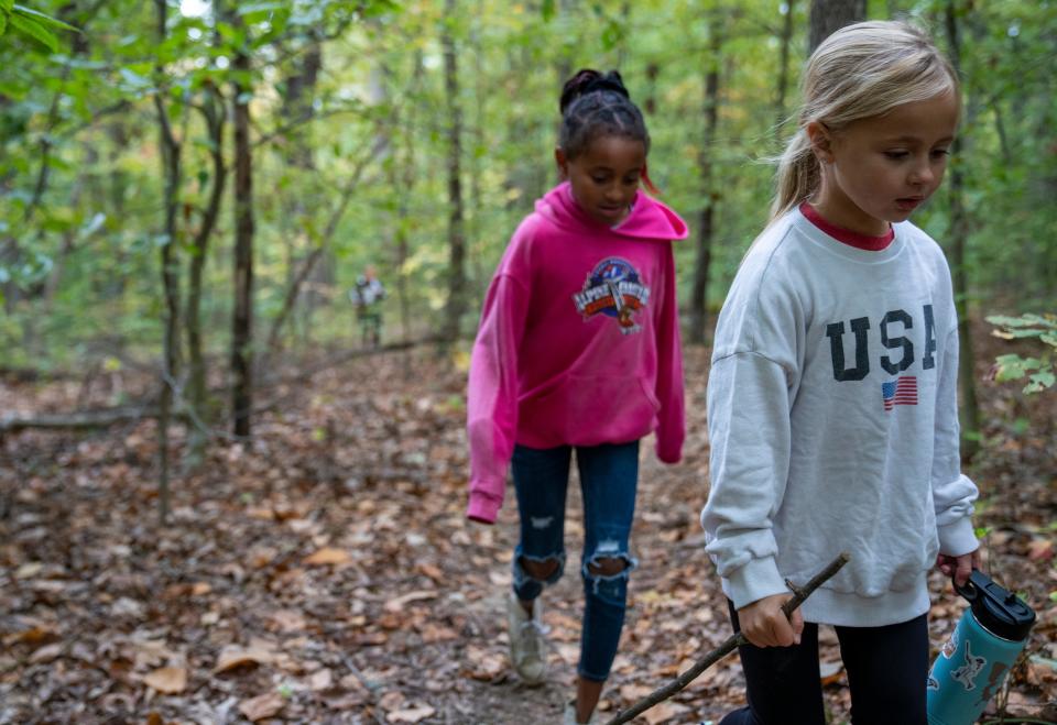 Catalina Hessman (left), 9, and Nora Tumey, 6, hike up Browning Hill in a remote part of Brown County. The girls had joined their aunt Shannon Sexson and several other relatives for a day of exploring in the woods.