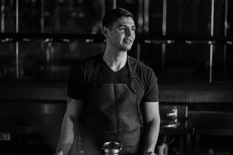 Black and white photo of the chef, Andrew Sheridan, as he looks away from the camera