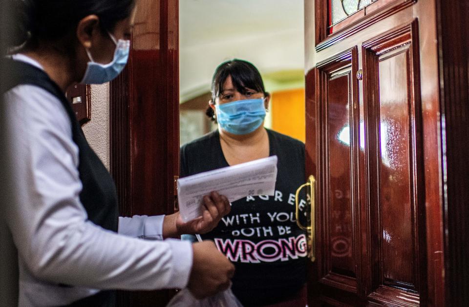 A health worker speaks with a woman while on door-to-door visits to carry out COVID-19 tests in Mexico City, on June 16, 2020, amid the new coronavirus pandemic. (Photo by PEDRO PARDO / AFP) (Photo by PEDRO PARDO/AFP via Getty Images)