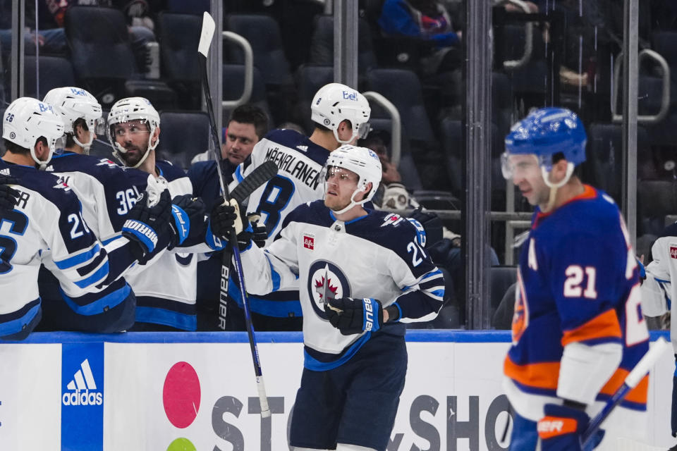 Winnipeg Jets' Nikolaj Ehlers (27) celebrates with teammates after scoring a goal as New York Islanders' Kyle Palmieri (21) reacts during the second period of an NHL hockey game Wednesday, Feb. 22, 2023, in Elmont, N.Y. (AP Photo/Frank Franklin II)