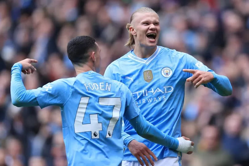 Erling Haaland (R) celebrates with Phil Foden of Manchester City