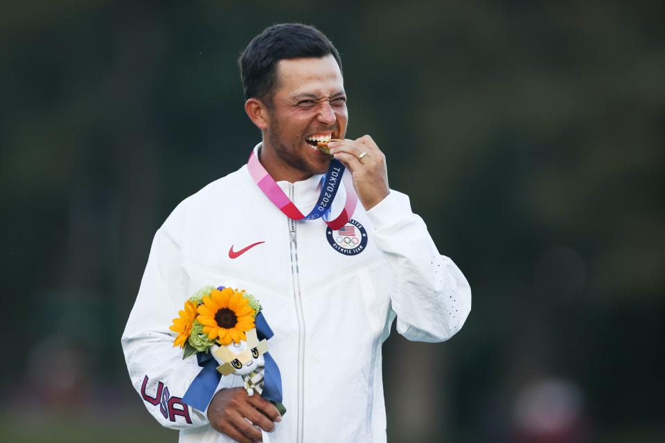 Gold medalist Xander Schauffele of the United States bites his medal during the awarding ceremony of the men's individual stroke play of golf match at Tokyo 2020 Olympics in Saitama, Japan, Aug. 1, 2021. (Photo by Zheng Huansong/Xinhua via Getty Images)