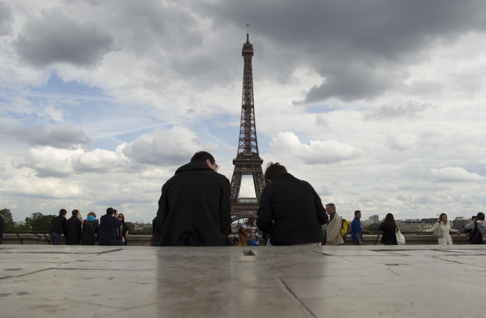 FILE - This May 7, 2012 file photo shows people admiring the view of The Eiffel Tower in Paris. (AP Photo/Laurent Cipriani, file)