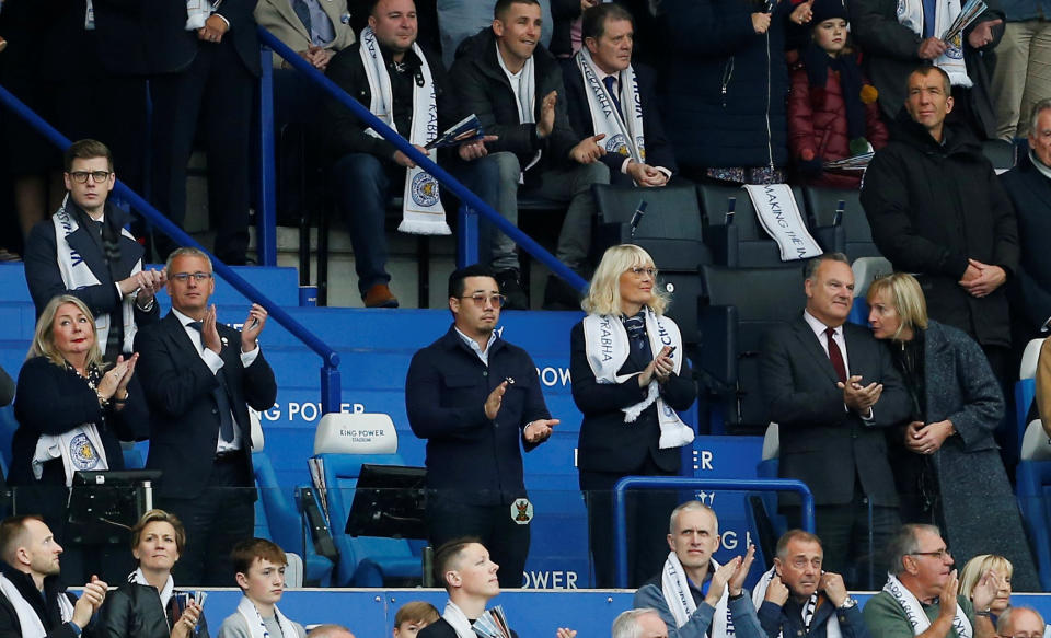 Khun Vichai's son, Top, stands next to his father's empty seat during last weekend's tributes at Leicester's King Power Stadium. (Credit: Reuters)