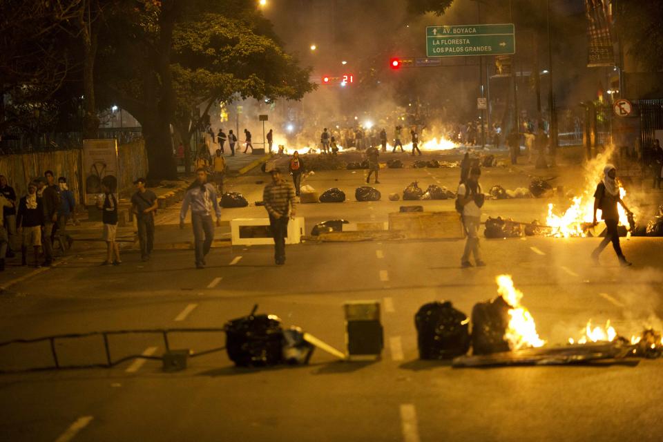 Objects placed by opposition protesters block a road in the Altamira neighborhood of Caracas, Venezuela, Thursday, Feb. 20, 2014. Violence is heating up in Venezuela as an opposition leader faces criminal charges for organizing a rally that set off escalating turmoil in the oil-rich, but economically struggling country. (AP Photo/Rodrigo Abd)