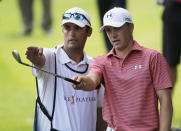 Jordan Spieth, left, and his caddie Michael Greller gesture from the eighth fairway during the final round of The Players championship golf tournament at TPC Sawgrass, Sunday, May 11, 2014 in Ponte Vedra Beach, Fla. (AP Photo/Gerald Herbert)