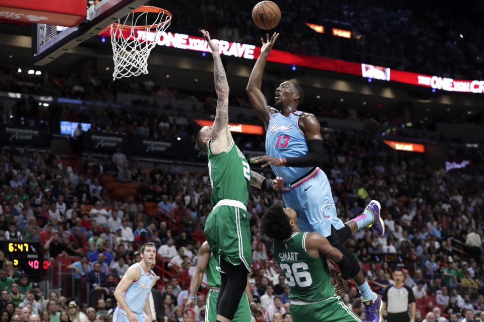 Miami Heat forward Bam Adebayo (13) goes to the basket as Boston Celtics center Daniel Theis (27) and guard Marcus Smart (36) defend during the first half of an NBA basketball game, Tuesday, Jan. 28, 2020, in Miami. Adebayo was called for an offensive foul on the play. (AP Photo/Lynne Sladky)