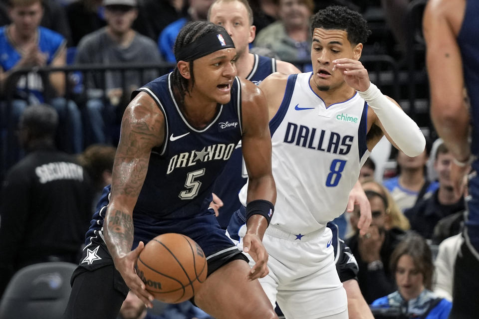 Orlando Magic's Paolo Banchero (5) makes a move to get to the basket past Dallas Mavericks' Josh Green (8) during the first half of an NBA basketball game, Monday, Nov. 6, 2023, in Orlando, Fla. (AP Photo/John Raoux)