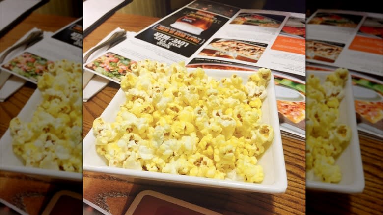 Bowl of popcorn on table with Ninety Nine Restaurant menus