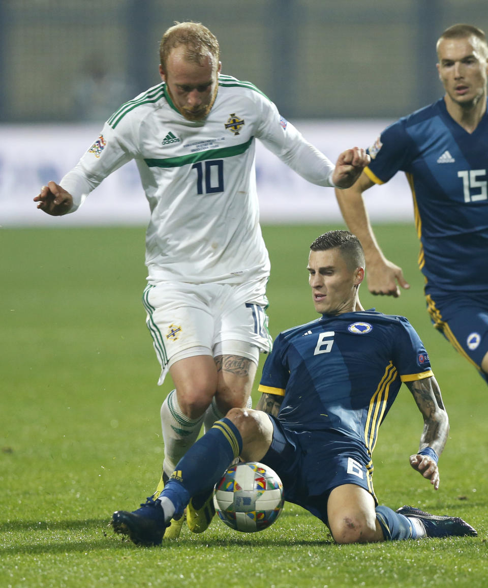 Northern Ireland's Liam Boyce, left, is tackled by Bosnia's Ognjen Vranjes during the UEFA Nations League soccer match between Bosnia and Northern Ireland at the Grbavica stadium, in Sarajevo, Bosnia, Monday, Oct. 15, 2018. (AP Photo/Amel Emric)