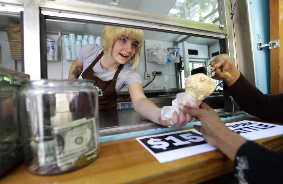 Caitlyn Faircloth, a worker with Molly Moon's Homemade Ice Cream, hands out free ice cream in 2014. Business across the company's nine scoop shops is down 40% in 2020. (Photo: ASSOCIATED PRESS)
