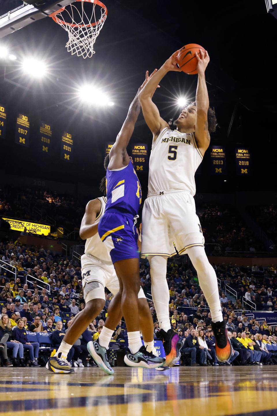 Michigan Wolverines forward Terrance Williams II (5) is fouled by McNeese State Cowboys guard Shahada Wells (13) in the first half at Crisler Center in Ann Arbor on Friday, Dec. 29, 2023.