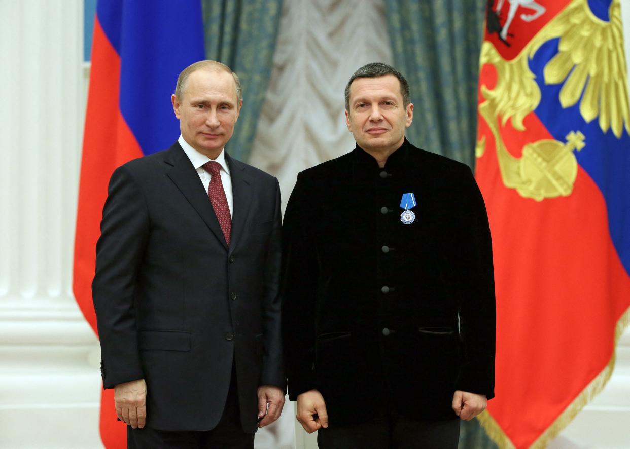 In this picture taken on December 25, 2013 Russian President Vladimir Putin poses with TV anchor Vladimir Solovyov during an awards ceremony at the Kremlin in Moscow. - Moscow said on April 25, 2022 it had arrested members of a 