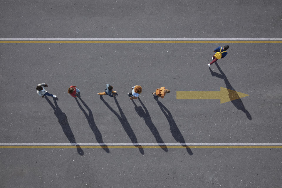 Group of young adults, photographed from above, on various painted tarmac surface, at sunrise.