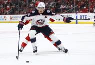 Columbus Blue Jackets defenseman Zach Werenski (8) is pursued by Detroit Red Wings right wing Alex DeBrincat during the first period of an NHL hockey game Tuesday, March 19, 2024, in Detroit. (AP Photo/Duane Burleson)