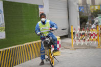 A municipal worker rides a bicycle on a street in Beijing, China, Thursday, March 21, 2024. China’s first generation of migrant workers played an integral role in the country's transformation from an impoverished nation to an economic powerhouse. Now, they're finding it hard to find work, both because they're older and the economy is slowing. (AP Photo/Tatan Syuflana)