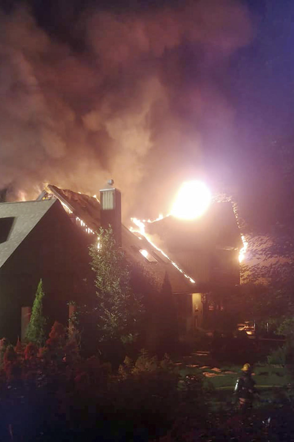 En esta foto del 9 de agosto de 2020, un gran incendio consume la casa de la estrella de programas de cocina Rachael Ray en Lake Luzerne, Nueva York. (Kenneth Dickinson vía AP)