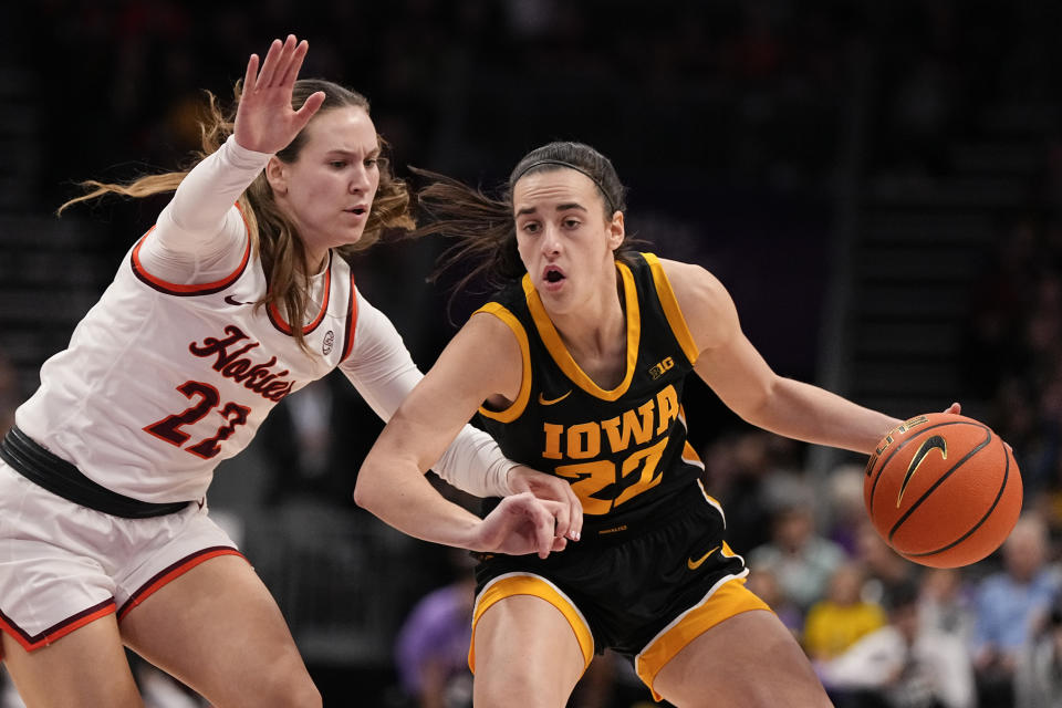 Iowa guard Caitlin Clark, right, drives to the basket past Virginia Tech guard Cayla King during the first half of an NCAA women's college basketball game Thursday, Nov. 9, 2023, in Charlotte, N.C. (AP Photo/Chris Carlson)